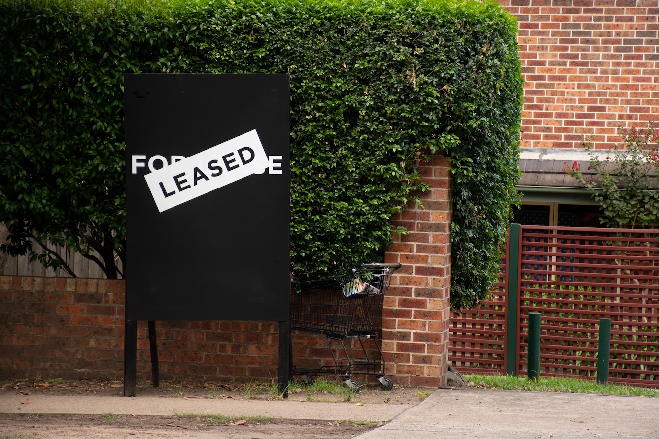 For lease and leased sign on a black display outside of a resedential building